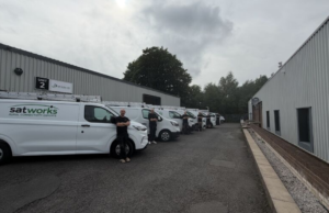 Satworks team beside branded installation vans
